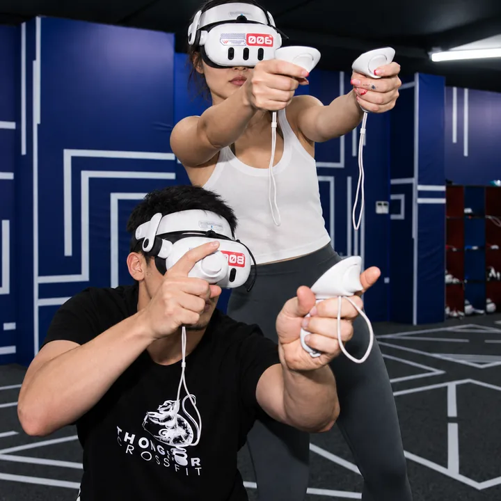 Two players in VR headsets point their controllers forward at Another World Da Nang.