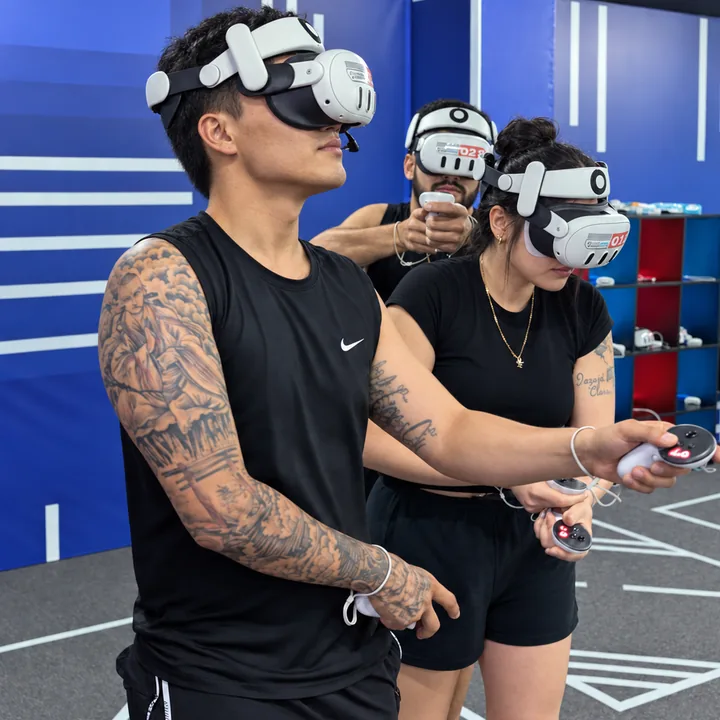 Three players in black clothing stand close together with VR headsets and controllers at Another World Da Nang.