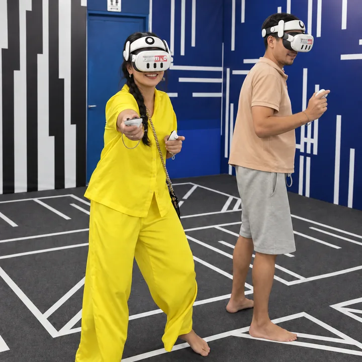 A smiling player in yellow extends a VR controller beside another player at Another World Da Nang.